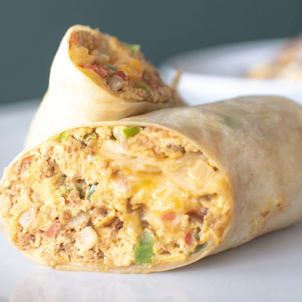 Two breakfast burritos from The Easy Egg, filled with eggs, cheese, and vegetables.